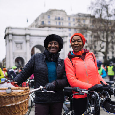 Woman with Dutch bike and basket standing next to friend
